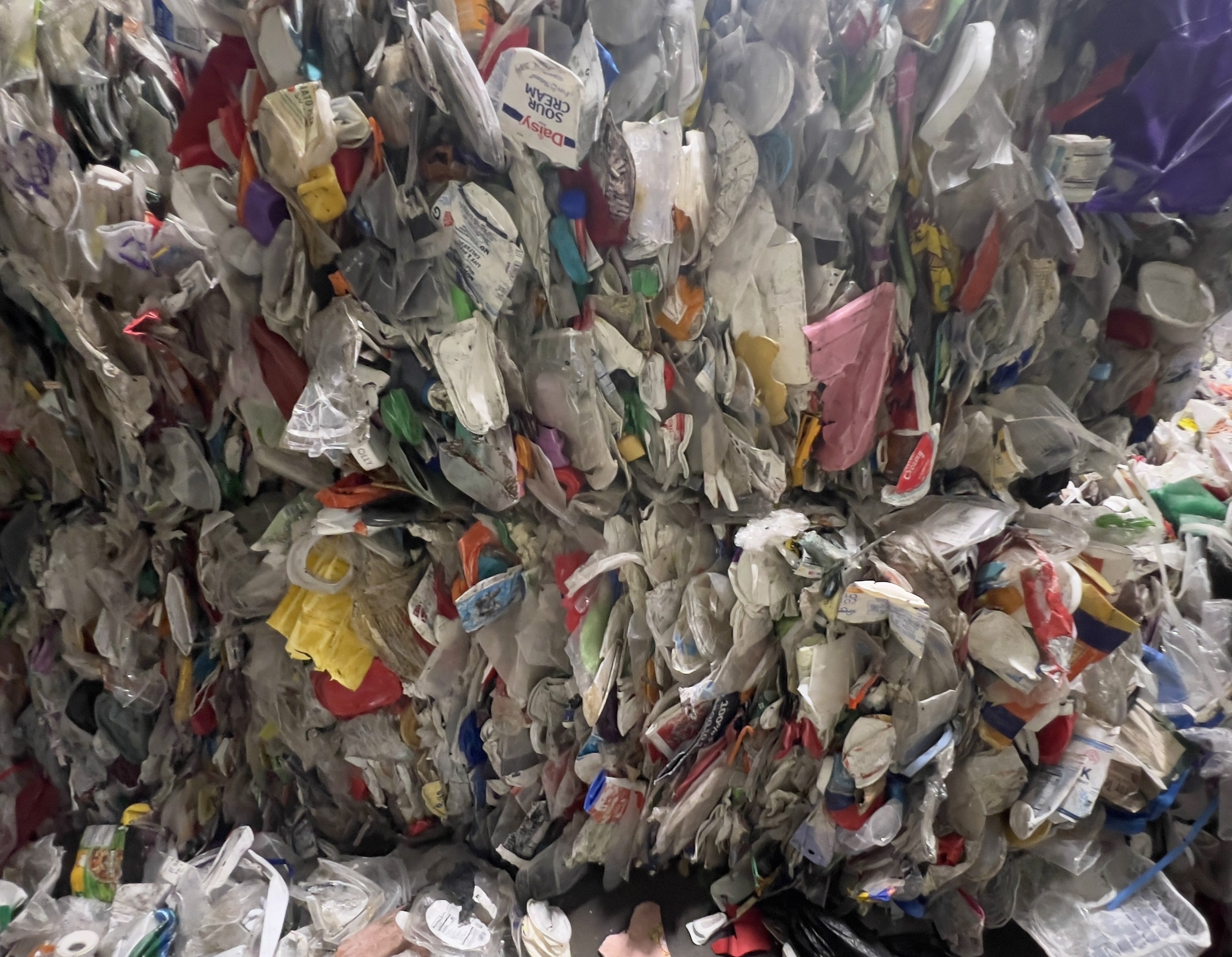 Close-up of recycled polypropylene bale with yogurt cups, food containers and packaging waste